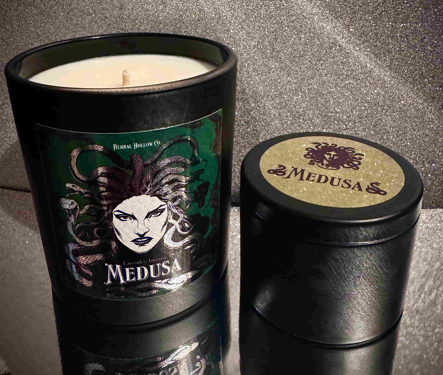 Large and small sized Medusa candles, a fantasy-inspired handcrafted candle with plum, lavender, and incense scent in mythology-themed design.