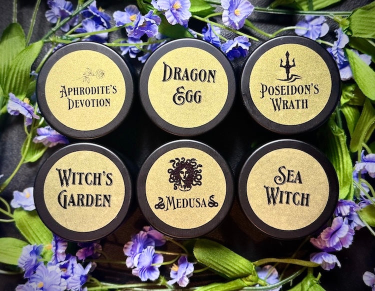 Handmade small 4oz fantasy-themed scented candles with gold labels.