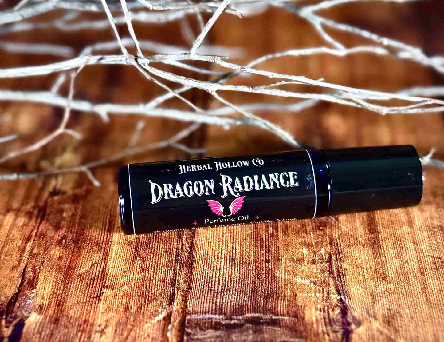 Image of small perfume bottle lying down. Dragon Radiance is a fantasy-inspired rollerball fragrance oil perfume, featuring a handcrafted magical vanilla, lavender, yang yang, amber, sandalwood, and musk scent.