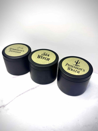 Three small black candles with labeled lids on a white background