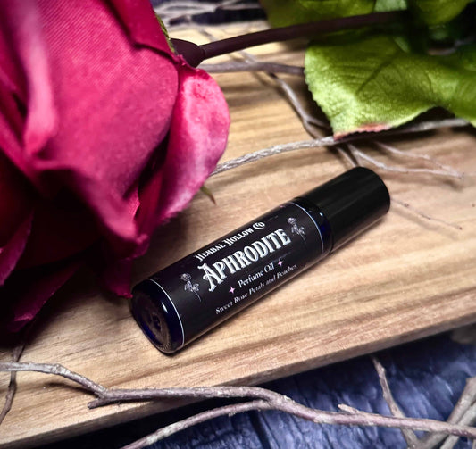 Aphrodite mythology-inspired rollerball fragrance oil perfume, featuring a handcrafted magical rose and peach scent in a portable glass bottle.