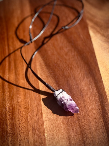 Large rough cut white and purple Amethyst crystal necklace on a wooden surface