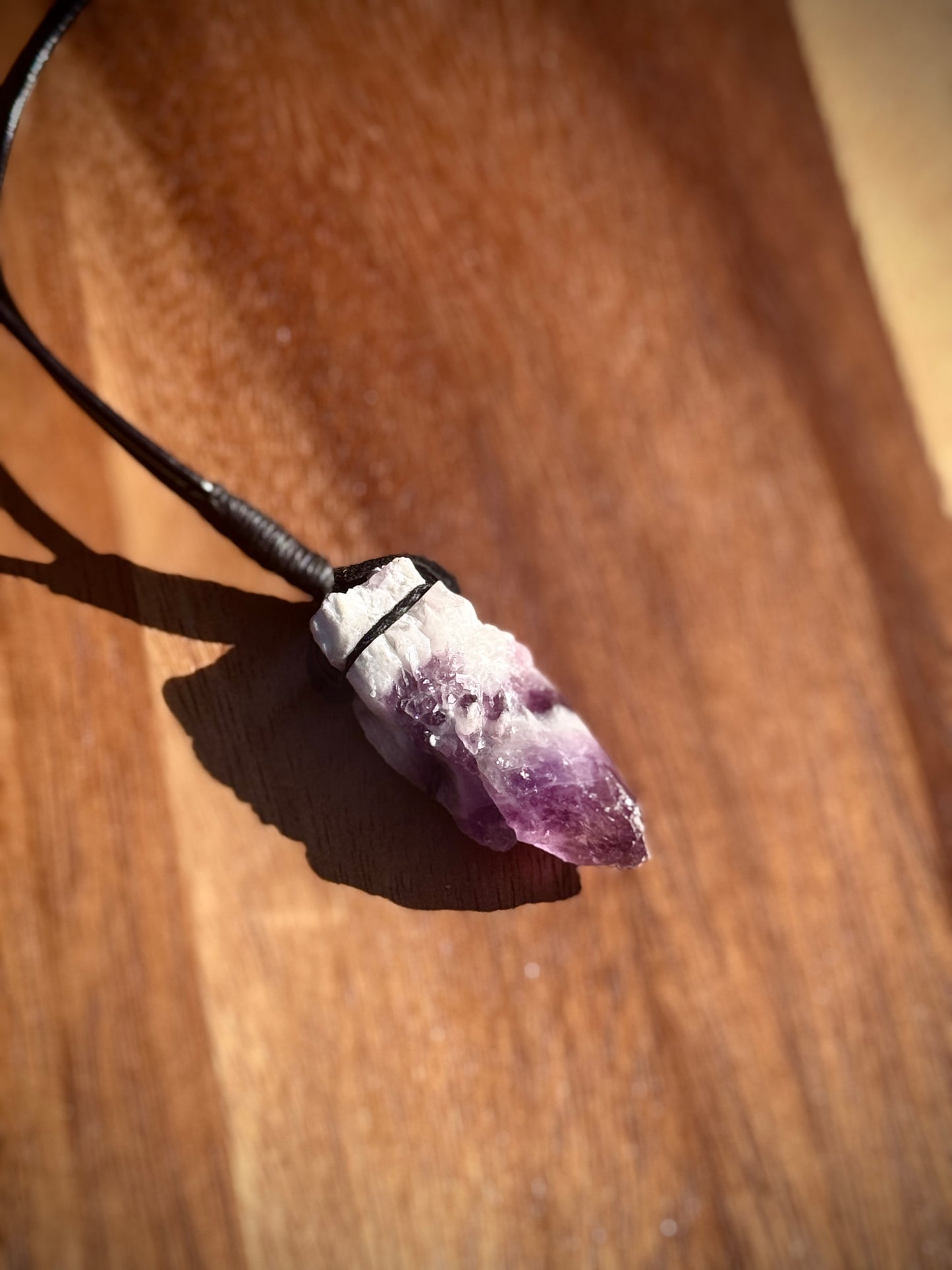Large Amethyst crystal necklace on a wooden surface