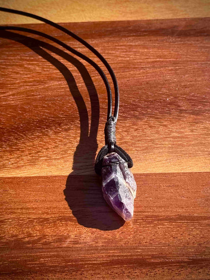 Amethyst crystal necklace on a wooden surface