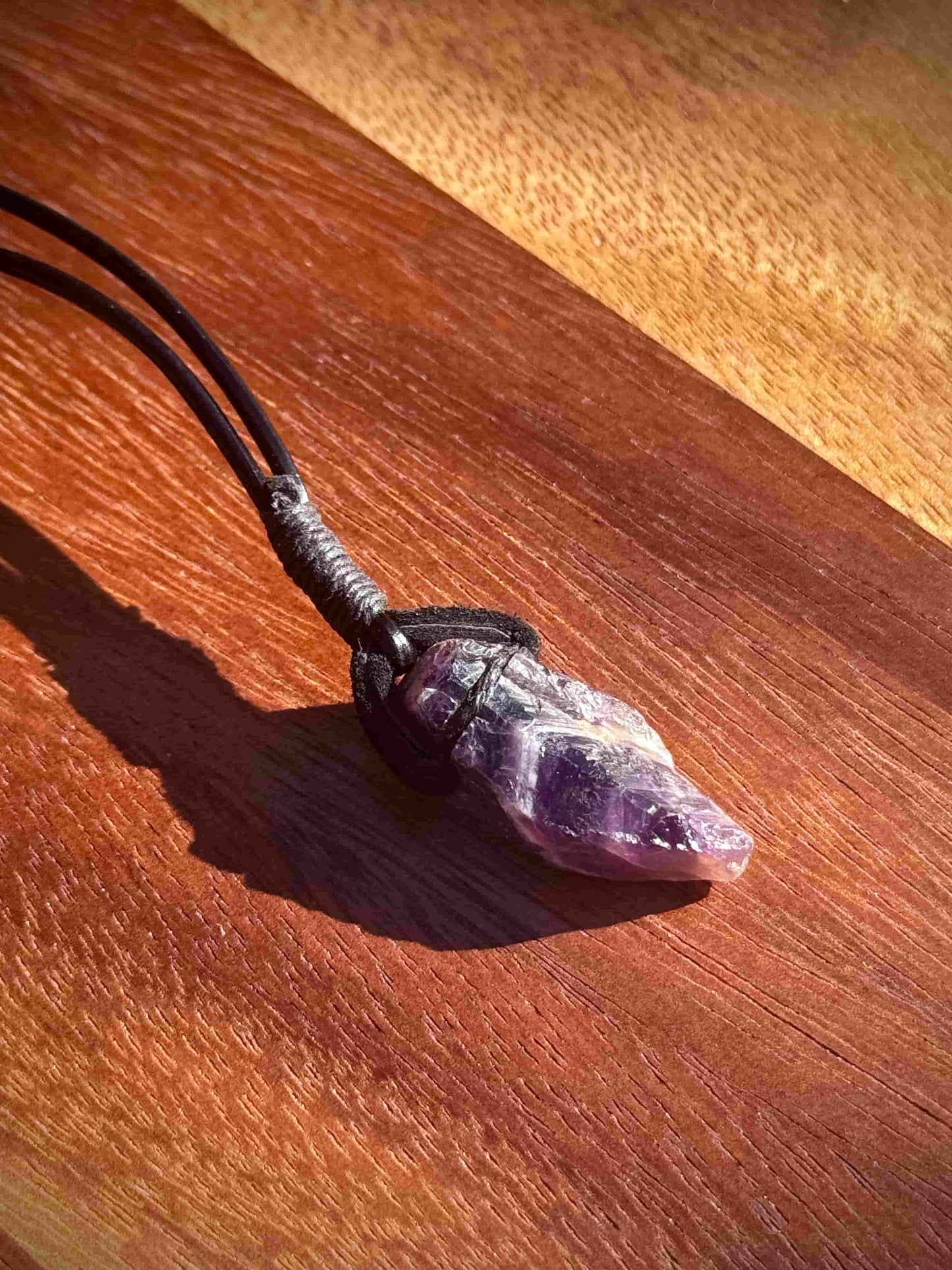 Amethyst crystal necklace on a wooden surface