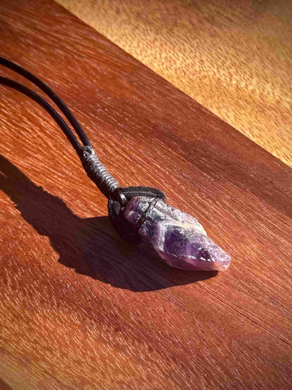 Amethyst crystal necklace on a wooden surface