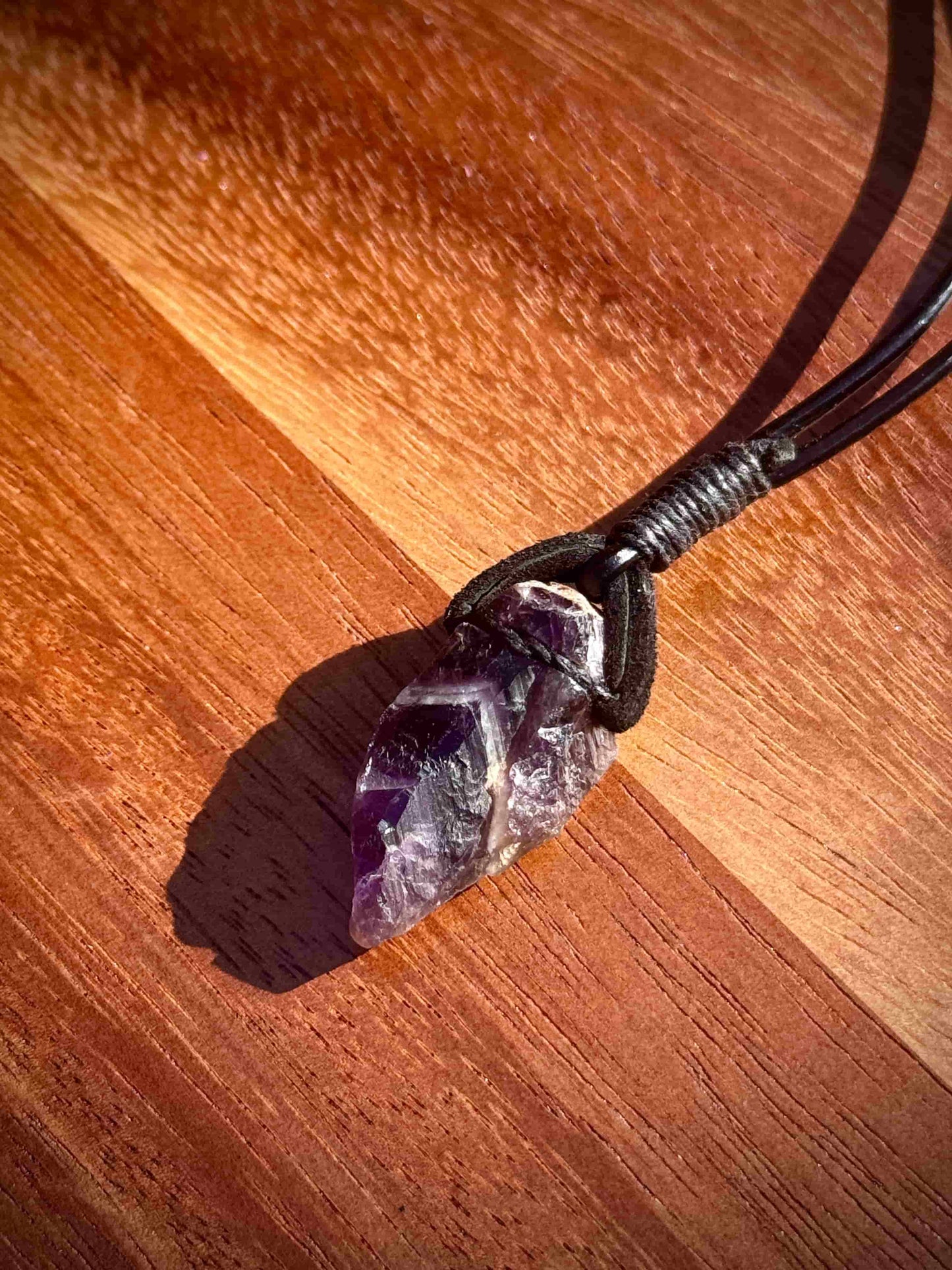 Amethyst crystal necklace on a wooden surface