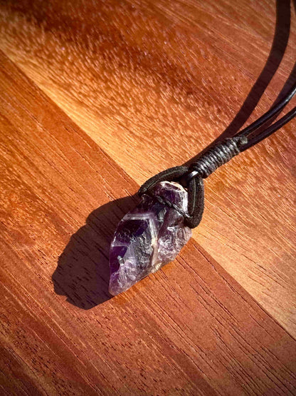 Amethyst crystal necklace on a wooden surface