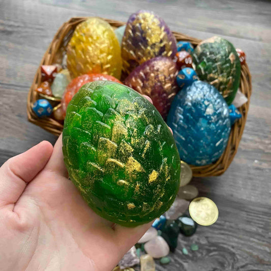 Dragon scale egg soaps in green, pink, purple, orange, yellow, and blue with gold glitter. Dice inside.