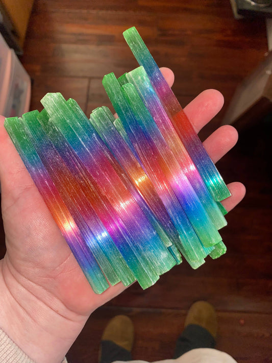 Rainbow-dyed selenite wands — vibrant, energy-cleansing crystal tools perfect for fantasy décor, rituals, and spiritual healing.