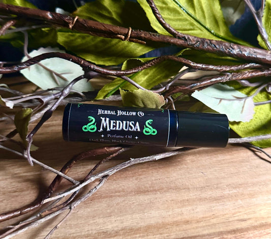 Medusa mythology-inspired rollerball fragrance oil perfume, featuring a handcrafted magical plum scent in a portable glass bottle.