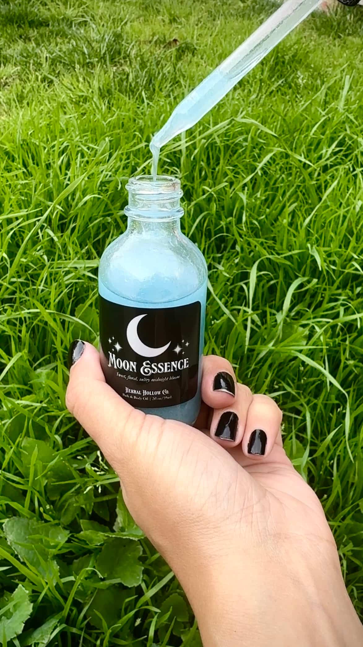 Herbal Hollow Co Moon Essence shimmering body oil with hydrating formula and gold glitter, inspired by fantasy and celestial beauty.