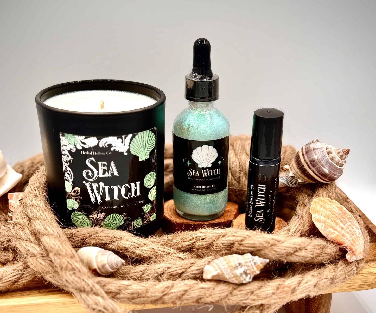 Sea Witch product set with candle, bottle, and rollerball on a wooden tray with rope and shells.