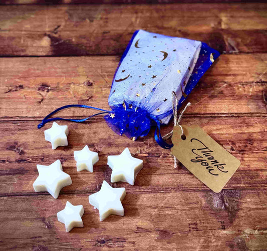 Herbal Hollow Co star-shaped scented wax melts in assorted magical scents, packaged in colorful celestial mesh pouches.