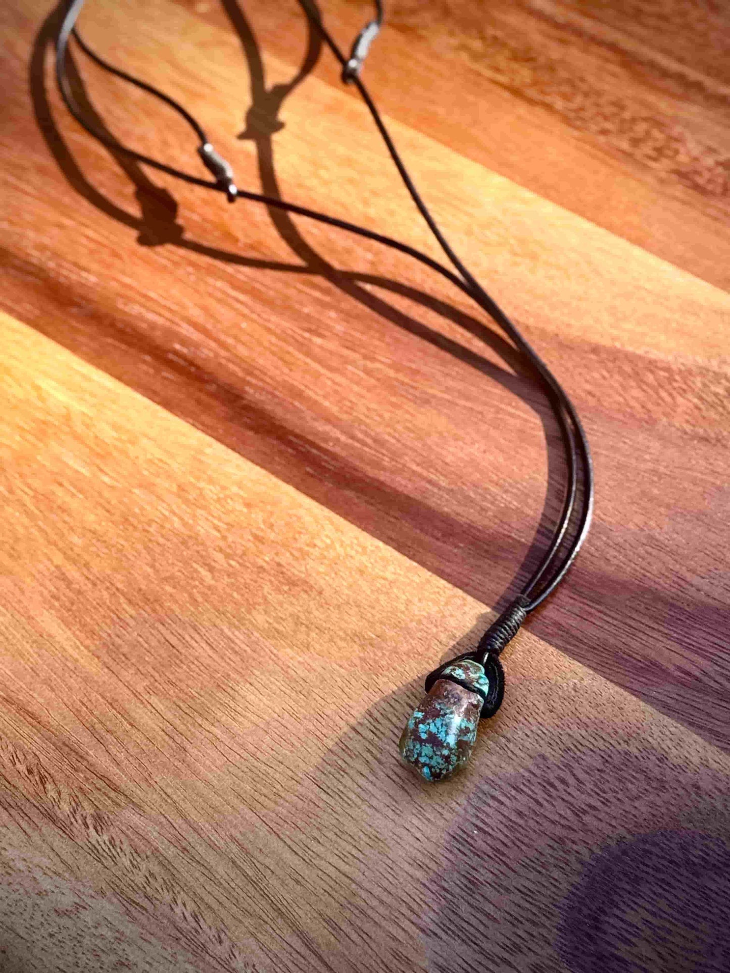 Necklace with a turquoise pendant on a wooden surface