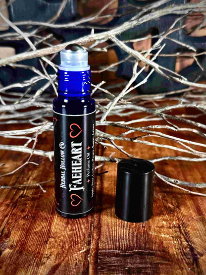 Image of small perfume bottle standing up with cap off. Faeheart is a fantasy-inspired rollerball fragrance oil perfume, featuring a handcrafted magical lychee, pear, apple, peony, and lotus flower scent in a portable glass bottle.