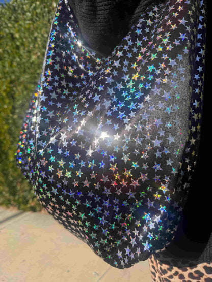 Holographic star-patterned bag with a blurred background
