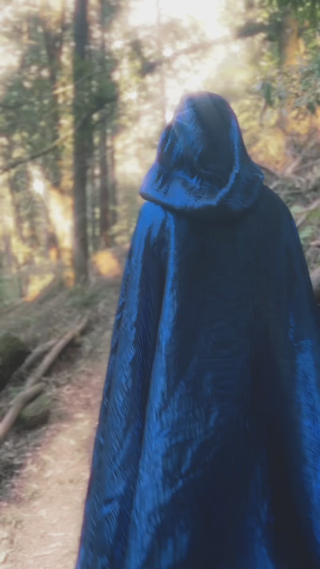 Video of handmade enchanting short and long iridescent lightweight capes in a forest, perfect for renaissance fairs, fantasy costumes, and magical cottagecore fashion.