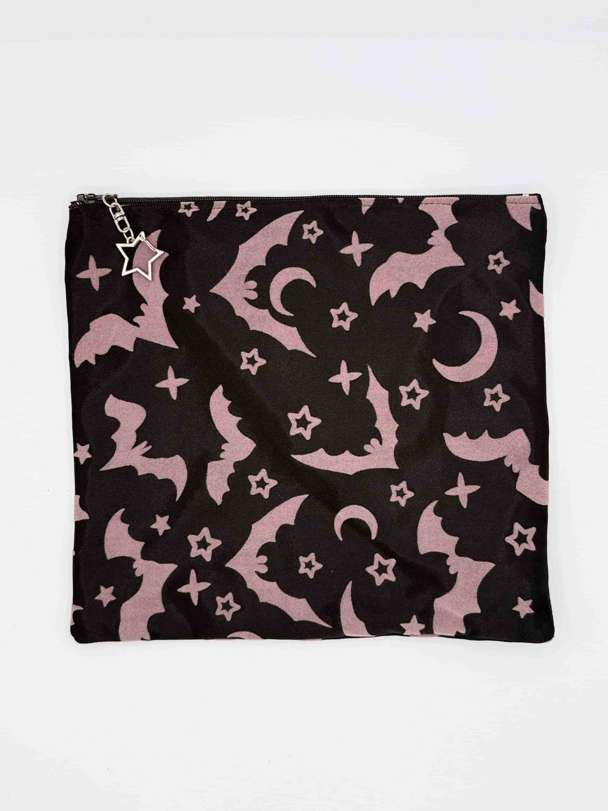 black with purple velvet bats, moons, and stars print travel bag pouch with silver star-shaped clasp on a zipper on a white background