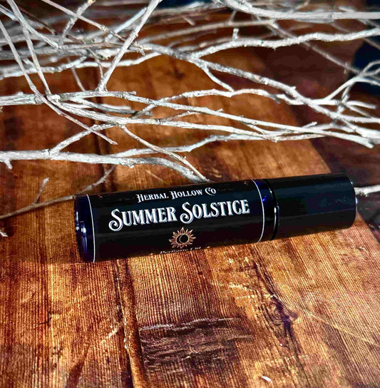Image of small perfume bottle lying down. Summer Solstice is a fantasy-inspired rollerball fragrance oil perfume, featuring a handcrafted magical citrus, ozone, red and black currant, jasmine, and peach scent.
